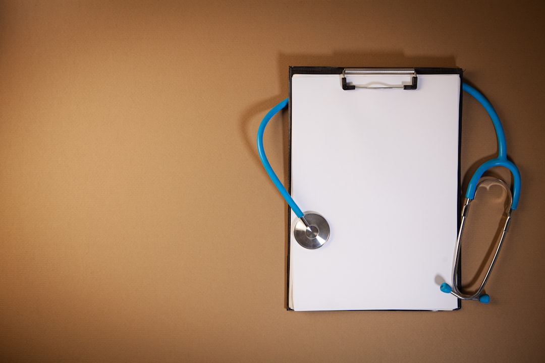 A stethoscope resting on a clipboard with blank paper on a textured surface